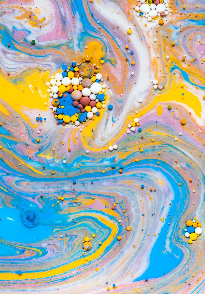A dynamic swirl of multicolored acrylic paint with floating bubbles, embodying modern art creativity.